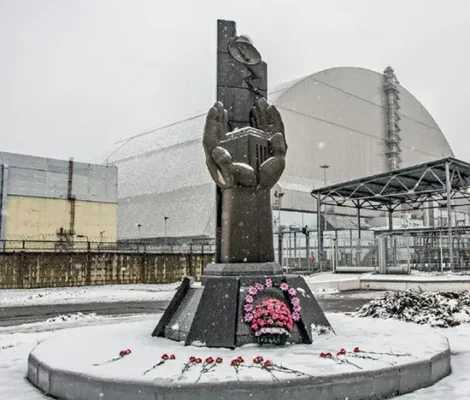 A 2017 photograph of the Chernobyl Victims Memorial located in front of reactor #4 at the Chernobyl nuclear power station. The reactor chamber is now sealed within a cement sarcophagus.