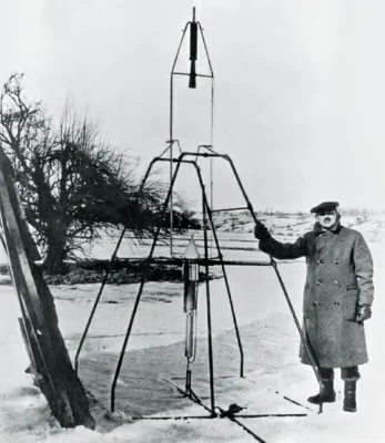 Robert Goddard posing with his first liquid-fueled rocket, launched from Auburn, Massachusetts, on March 16, 1926. This rocket had a combustion chamber and nozzle different from modern rockets.