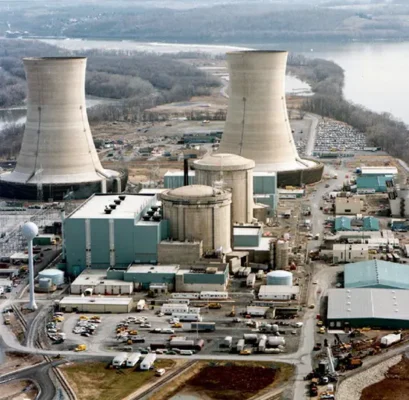 A 1979 photograph of the Three Mile Island nuclear generating station near Harrisburg, Pennsylvania. The cooling towers are the large structures, and the smaller cylindrical structures with rounded tops are the reactors.