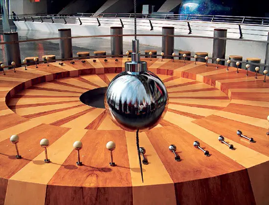 A substantial Foucault's pendulum displayed at the Príncipe Felipe Science Museum of the City of Arts and Sciences in Valencia, Spain. In this configuration, a small ball-and-stick model is gradually tilted approximately every 30 minutes due to the Earth's rotation beneath the pendulum's fixed plane of motion.