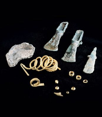 An assortment of Middle Bronze Age artifacts, including axes, chisels, rings, necklaces, and pendants discovered in England, dating back to 1300–1150 BCE