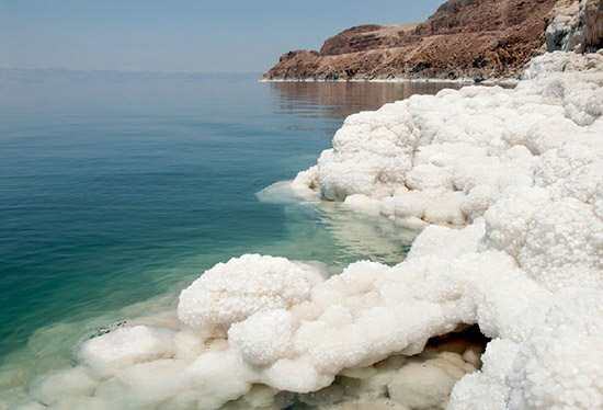 Salt-encrusted rocks along the shore of the slowly evaporating Dead Sea