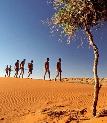 San (Bushmen) people crossing a sand dune in South Africa's Northern Cape region
