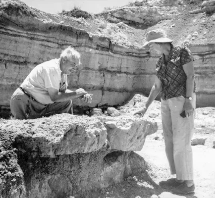 A 1960s photo of Mary Leakey (right) showing Louis Leakey (left) one of the places where she discovered fossils of early hominid species in Olduvai Gorge, Tanzania.