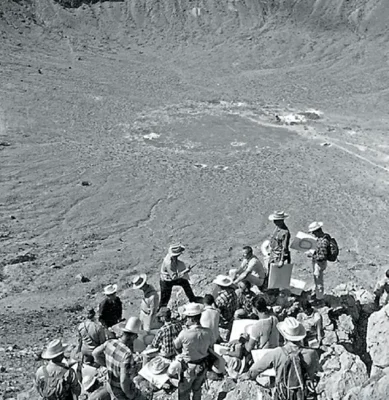 Geologist Eugene Shoemaker (center, holding hammer) lectures on the geology of impact craters to a group of astronauts at Meteor Crater, Arizona, in 1967.